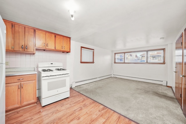 kitchen featuring baseboard heating, decorative backsplash, white gas range oven, and light hardwood / wood-style flooring