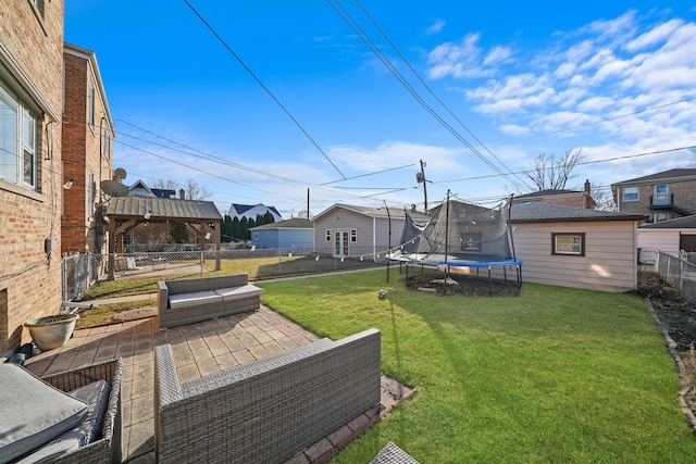 view of yard with a gazebo, a trampoline, an outbuilding, an outdoor hangout area, and a patio