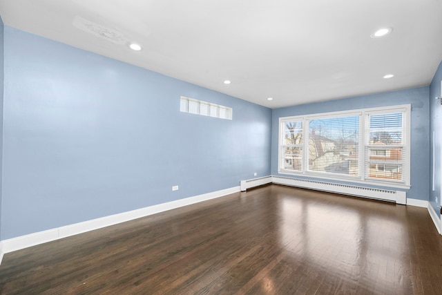 unfurnished room with hardwood / wood-style flooring and a baseboard radiator