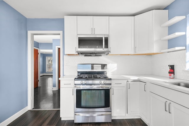 kitchen featuring stainless steel appliances, dark wood-type flooring, white cabinets, and backsplash