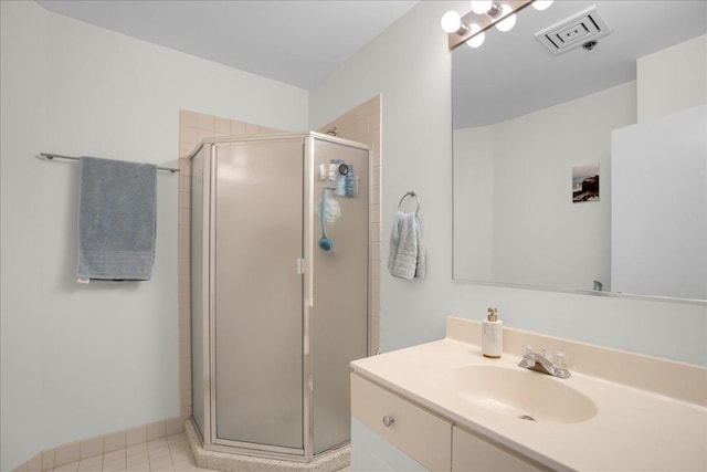 bathroom featuring walk in shower, vanity, and tile patterned flooring