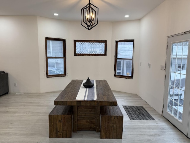 unfurnished dining area featuring light hardwood / wood-style flooring and a chandelier