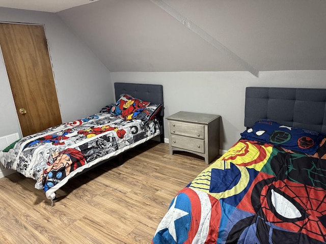 bedroom with wood-type flooring and lofted ceiling