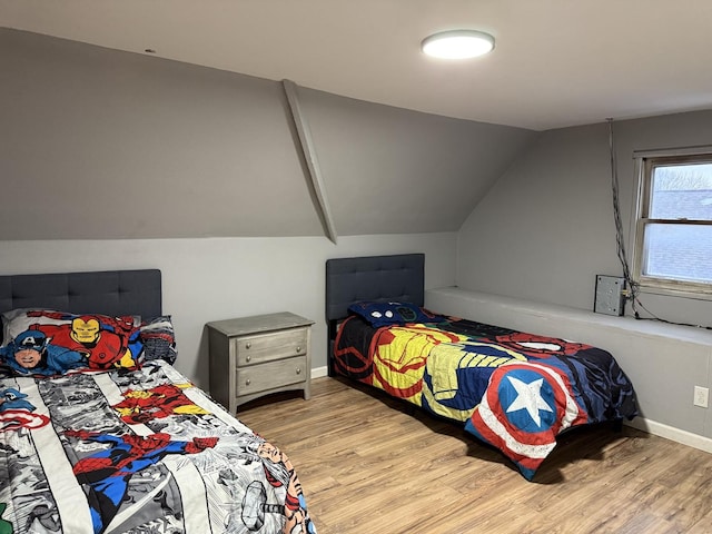 bedroom with lofted ceiling and light hardwood / wood-style floors