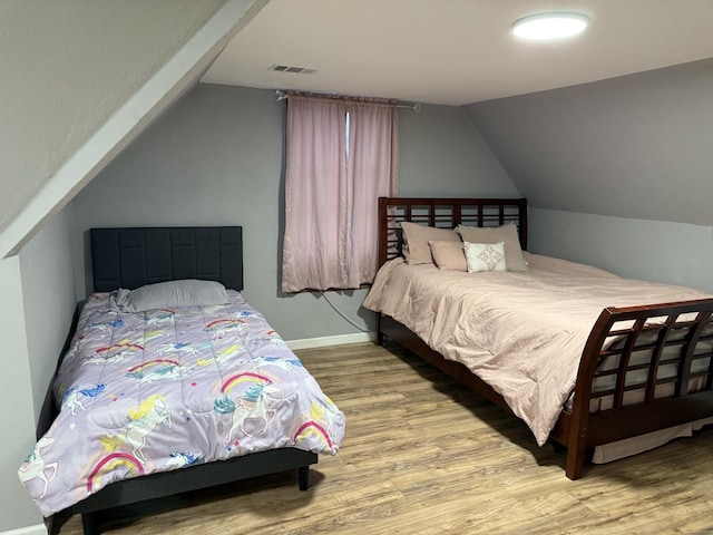 bedroom with hardwood / wood-style flooring and vaulted ceiling