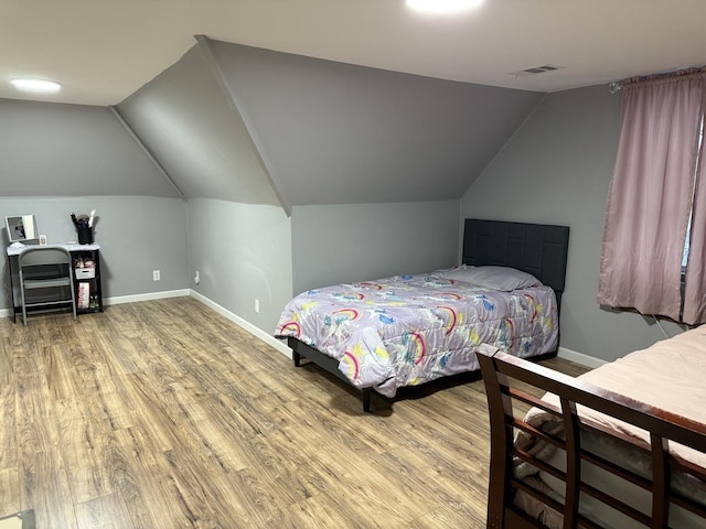 bedroom featuring vaulted ceiling and hardwood / wood-style floors