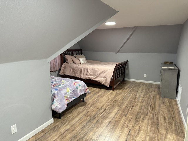 bedroom featuring hardwood / wood-style floors and vaulted ceiling