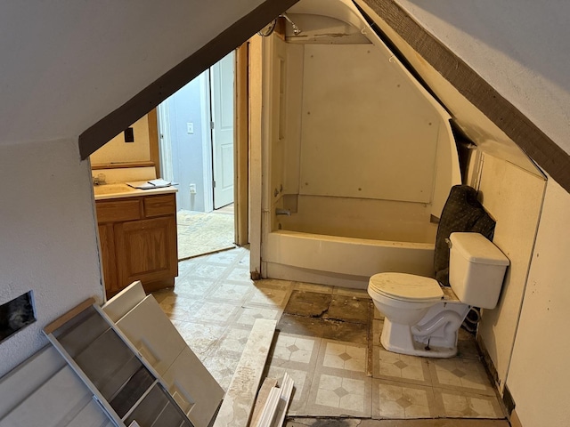 bathroom with a washtub, vanity, lofted ceiling, and toilet