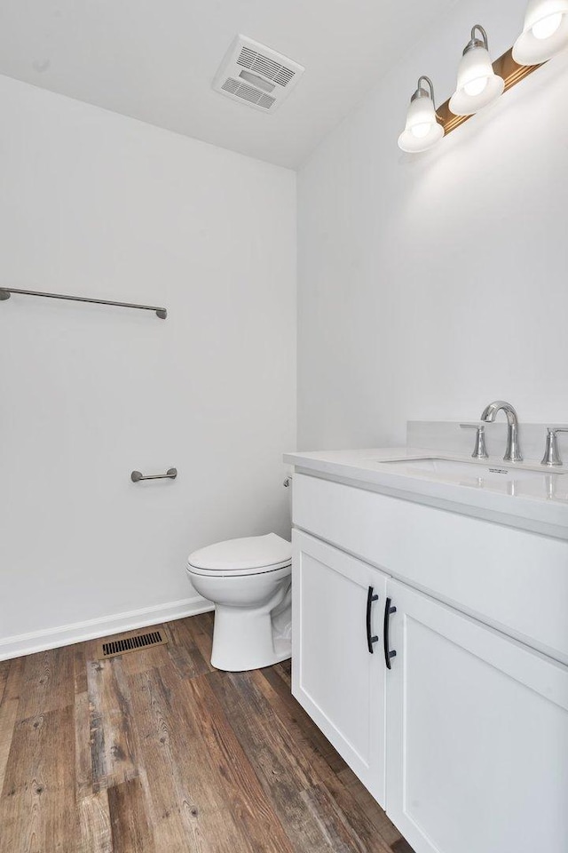 bathroom with vanity, hardwood / wood-style flooring, and toilet