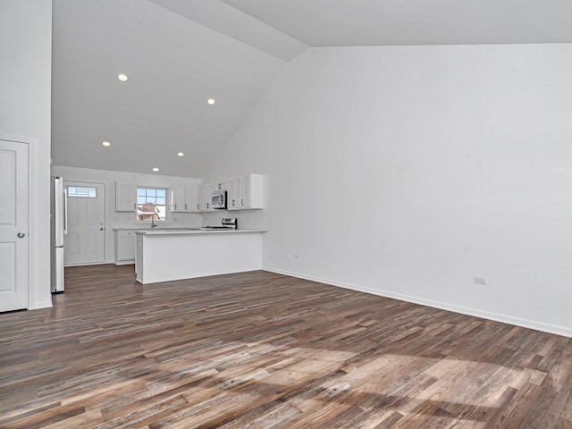 unfurnished living room featuring high vaulted ceiling, sink, and dark hardwood / wood-style flooring