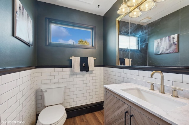 bathroom featuring vanity, wood-type flooring, tile walls, and toilet