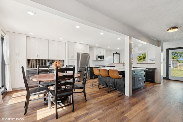 dining space featuring sink and wood-type flooring