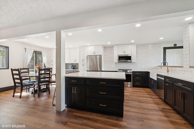 kitchen featuring white cabinetry, appliances with stainless steel finishes, dark hardwood / wood-style flooring, and tasteful backsplash