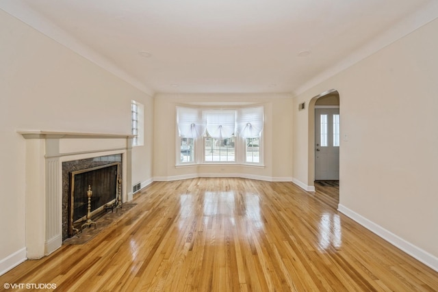 unfurnished living room with a premium fireplace, hardwood / wood-style floors, and a wealth of natural light