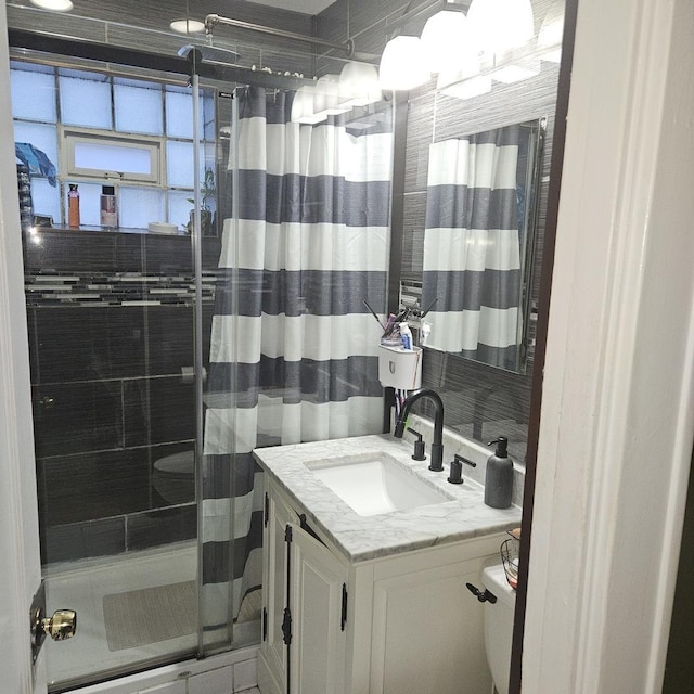 bathroom with vanity, a shower stall, and toilet