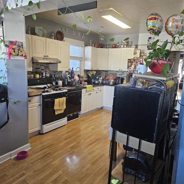 kitchen with light wood-type flooring, under cabinet range hood, range with gas stovetop, backsplash, and dishwasher