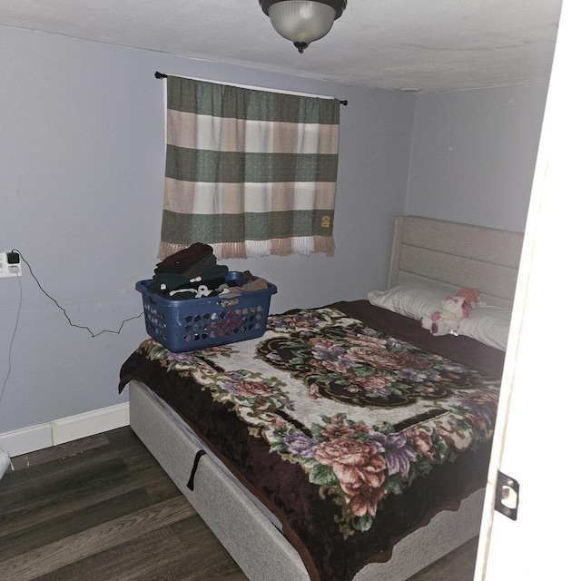 bedroom featuring wood finished floors and baseboards