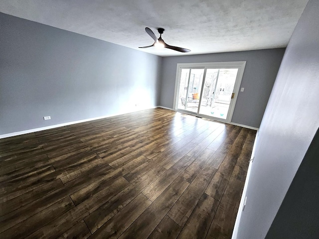 unfurnished room featuring dark wood-type flooring and ceiling fan