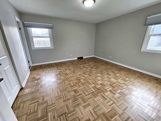 unfurnished room with a wealth of natural light and light parquet flooring