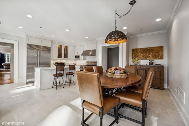 tiled dining space featuring ornamental molding