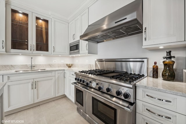 kitchen with sink, white cabinets, stainless steel appliances, light stone countertops, and wall chimney exhaust hood