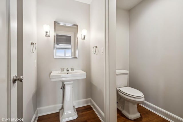 bathroom with hardwood / wood-style flooring and toilet