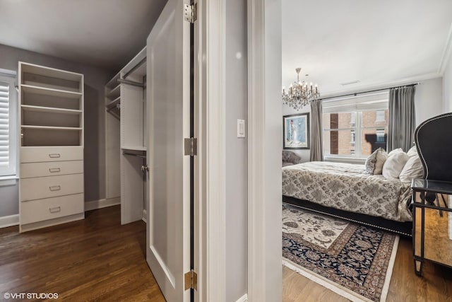 bedroom featuring dark hardwood / wood-style flooring and an inviting chandelier