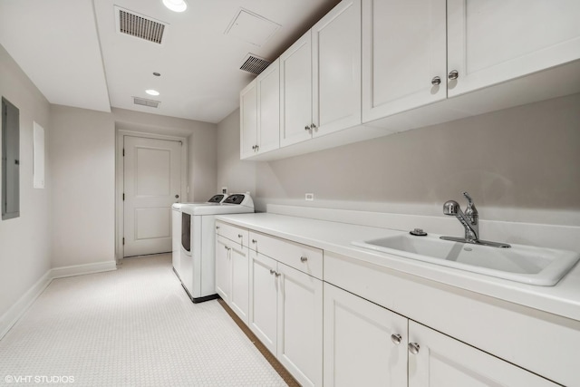 clothes washing area with cabinets, sink, washing machine and clothes dryer, and electric panel