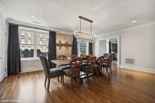 dining area featuring crown molding, an inviting chandelier, and dark wood-type flooring