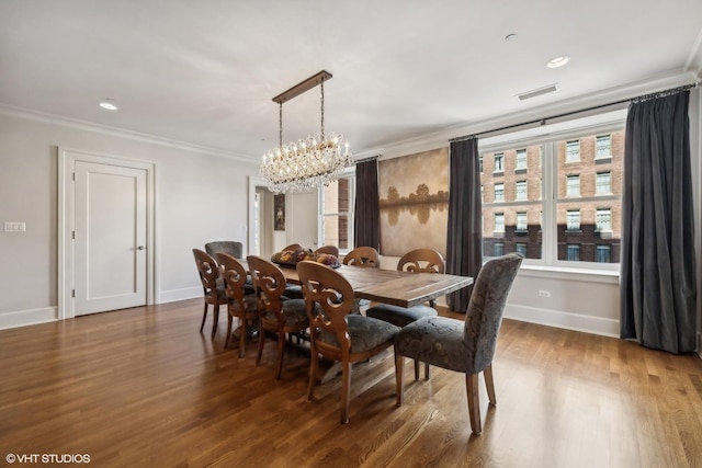 dining area with dark hardwood / wood-style flooring, ornamental molding, and an inviting chandelier