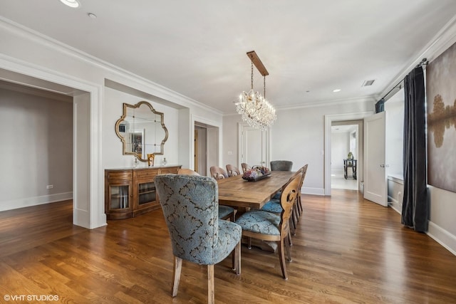 dining space with an inviting chandelier, crown molding, and dark wood-type flooring