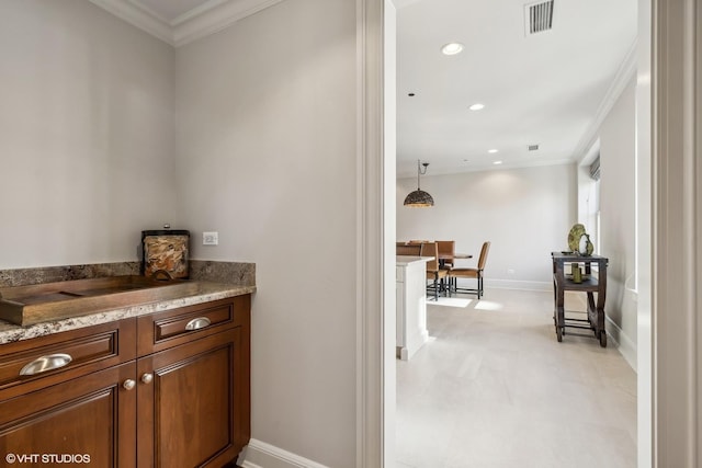 bar featuring pendant lighting, light stone counters, and crown molding