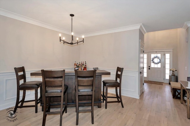 20375 Grosse Point Dr, Frankfort, IL 60423 - dining area with a chandelier, ornamental molding, light wood-type flooring, wainscoting, and a decorative wall