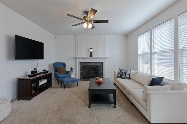 carpeted living room featuring ceiling fan and a fireplace