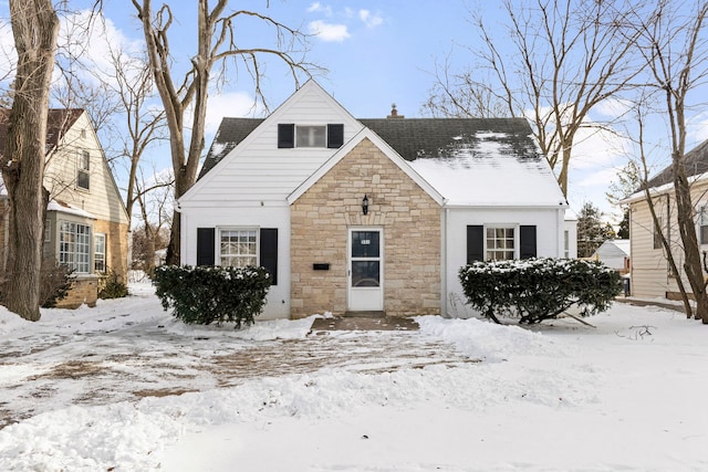 bungalow with stone siding and a chimney