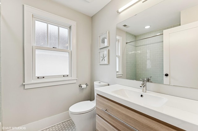 bathroom with vanity, tile patterned floors, toilet, and tiled shower