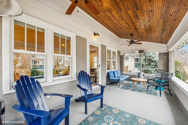 sunroom / solarium featuring vaulted ceiling, wooden ceiling, and ceiling fan