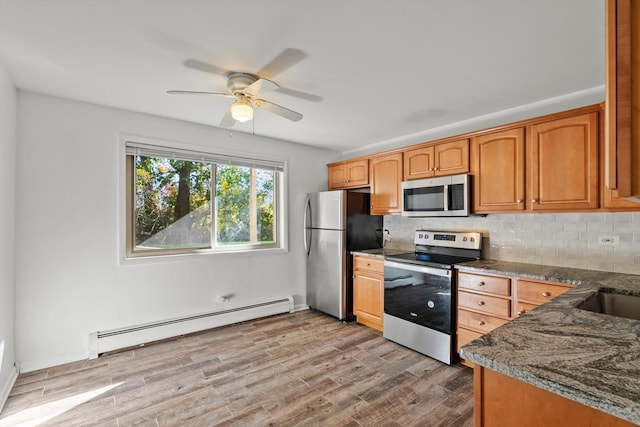 kitchen with decorative backsplash, a baseboard radiator, light hardwood / wood-style floors, and appliances with stainless steel finishes