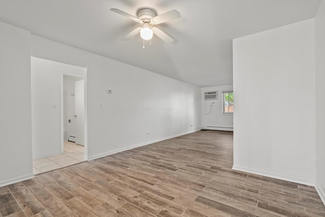 empty room with ceiling fan, an AC wall unit, a baseboard heating unit, and light hardwood / wood-style floors