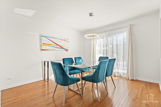 dining area with baseboards and light wood-type flooring