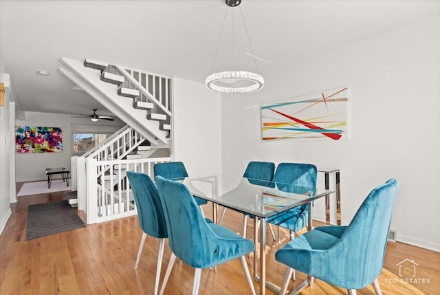 dining space with baseboards, stairs, and wood finished floors