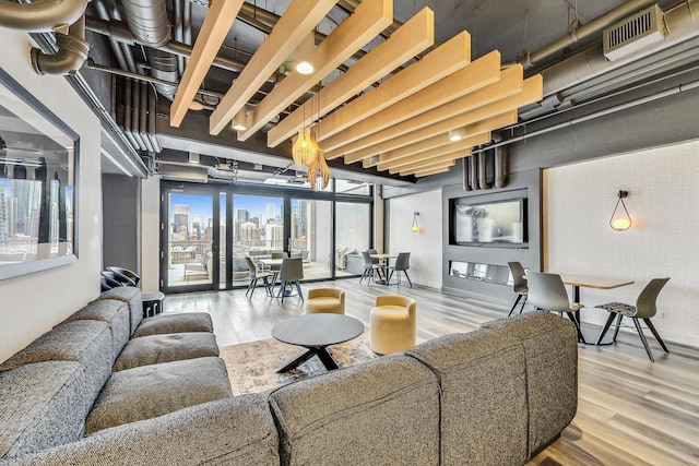 living room with a view of city, wood finished floors, and visible vents