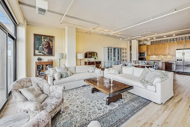 living area with light wood-style floors and visible vents