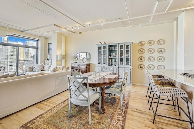 dining space featuring light wood-type flooring and baseboards