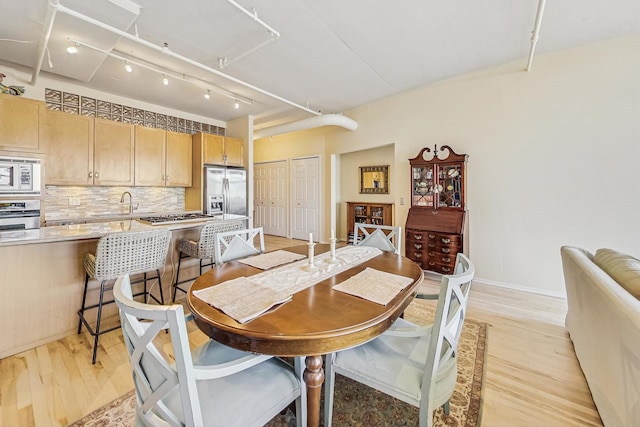 dining room featuring baseboards and light wood finished floors