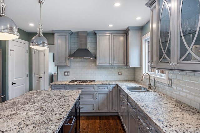 kitchen featuring wall chimney range hood, gray cabinets, and a sink