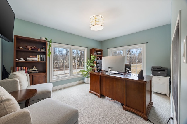 office area with baseboards, visible vents, and light carpet