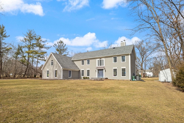 view of front of property with a chimney, a front yard, and roof with shingles