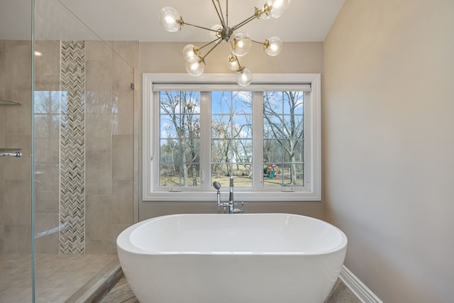 full bathroom featuring a freestanding tub, tiled shower, and baseboards