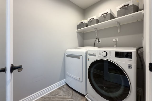 clothes washing area featuring laundry area, baseboards, and washer and clothes dryer